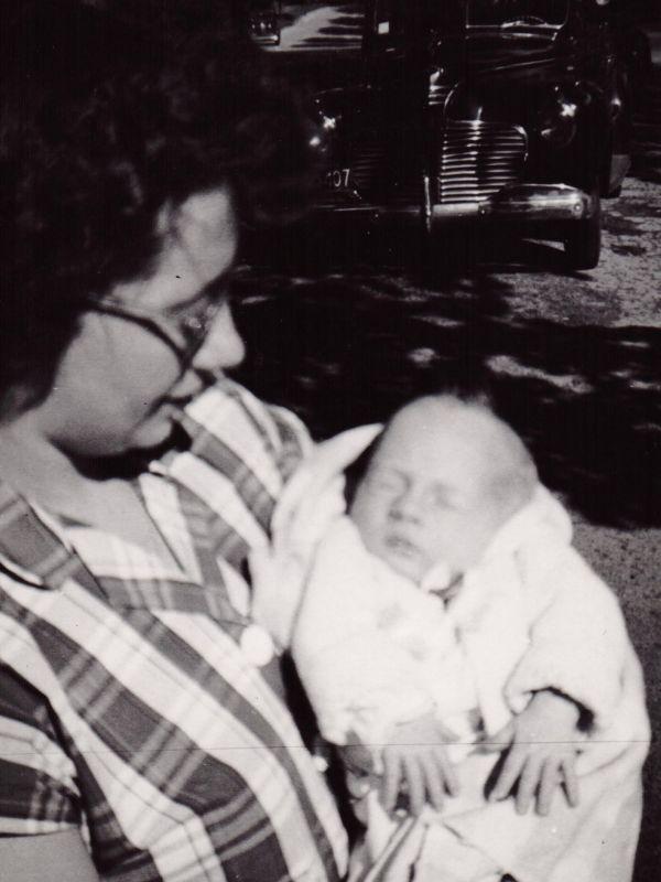 Liz holding Mickey outdoors arrving home from hospital, 1950